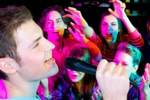 Junge Leute haben Spaß bei Karaokeparty
